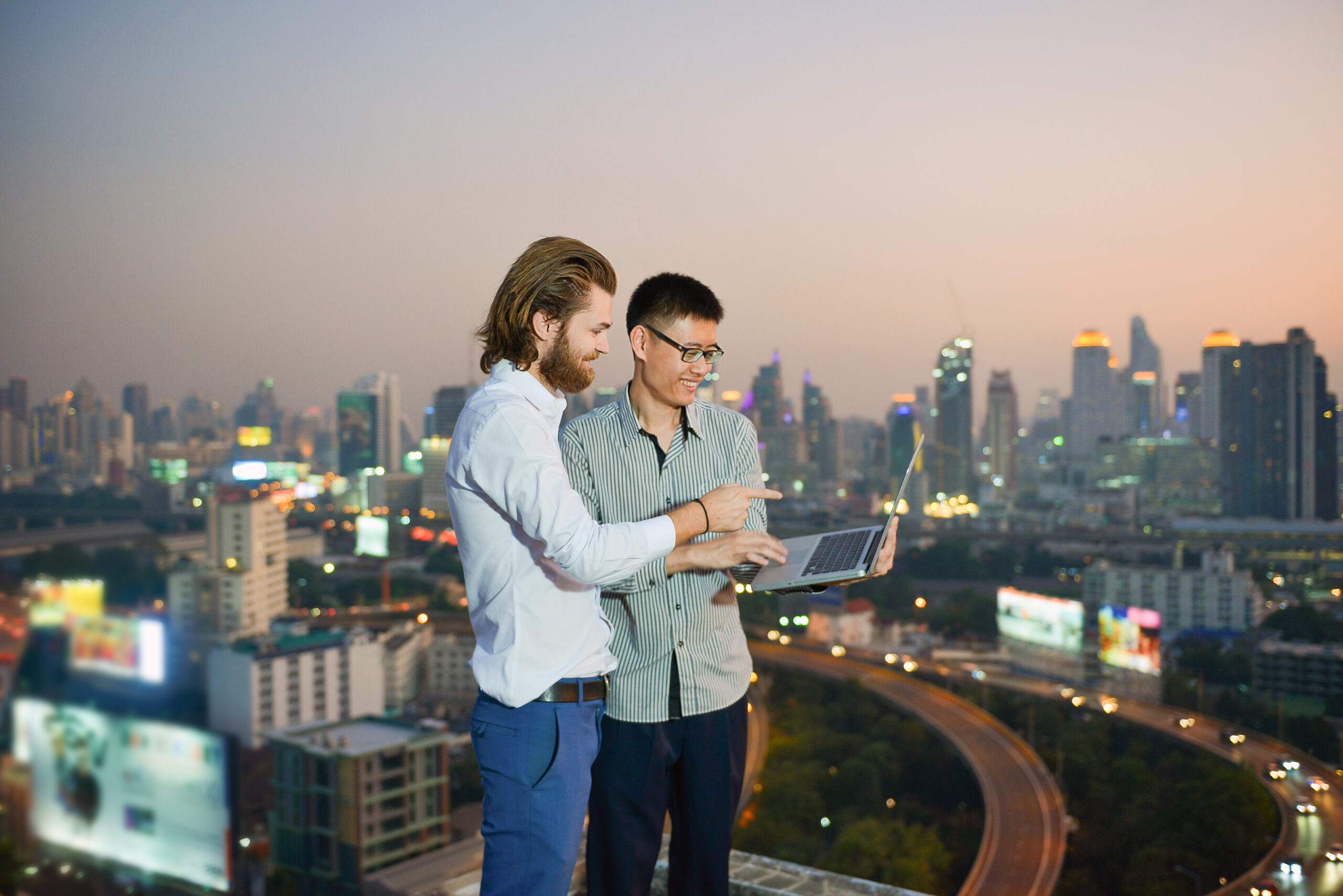 Group of business people working on a rooftop with blurry city background, business technology concept